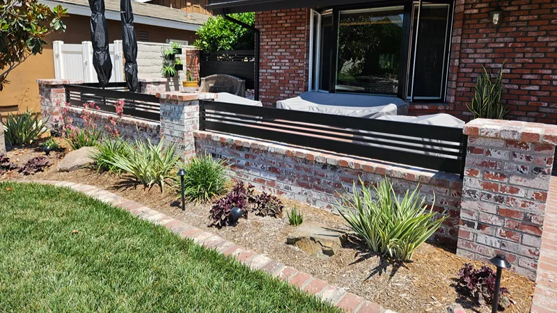 Completed residential garden bed with new plants and finishing materials