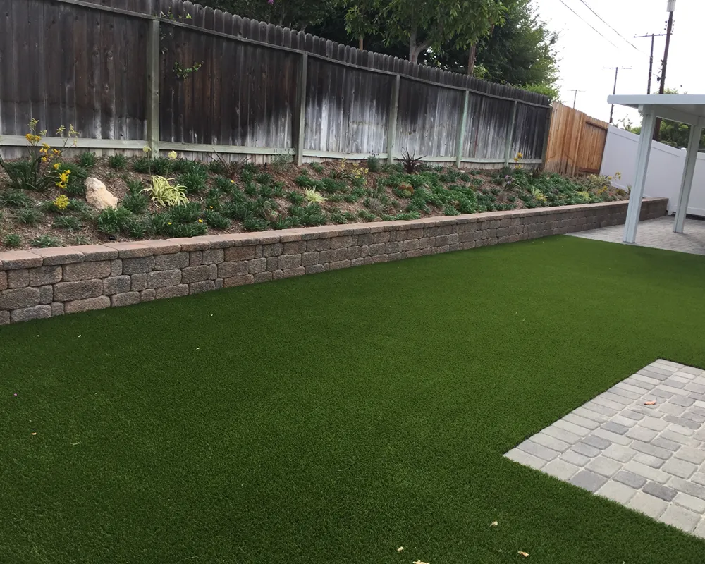 Artificial turf installed beside a residential patio and walkway