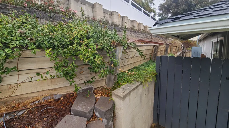 Sloped residential landscape before retaining wall construction